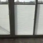 Miniaturka - Jasne plisy okienne podciągnięte od dołu do prawie całego zasłonięcia okna, ochrona prywatności u klienta w Kobyłce.