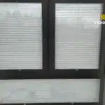 Miniaturka - Jasne plisy okienne na wymiar zamontowane w oknie trzyskrzydłowym w pokoju dziennym w Nadmie.